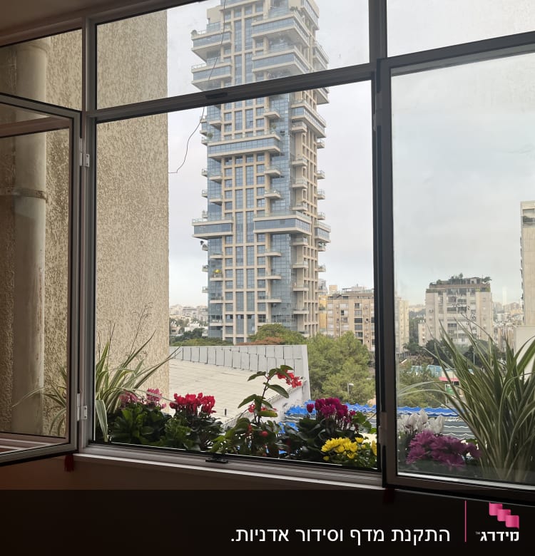 עציצים עם פרחים צבעוניים על אדן חלון פתוח